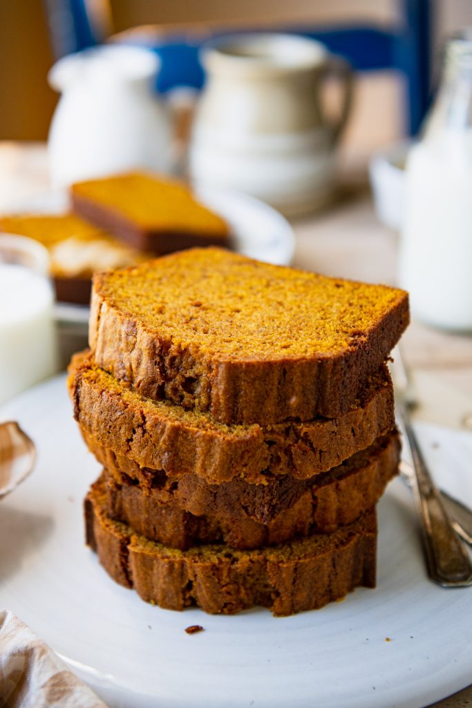 Close up shot of a stack of slices of easy pumpkin bread on a white platter