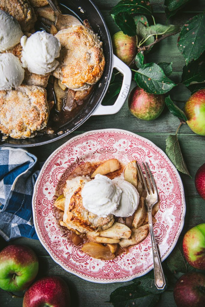 Overhead shot of traditional apple cobbler recipe served on a red and white antique bowl
