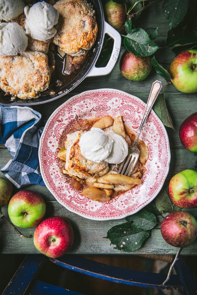 Apple cobbler with fresh apples on a green table