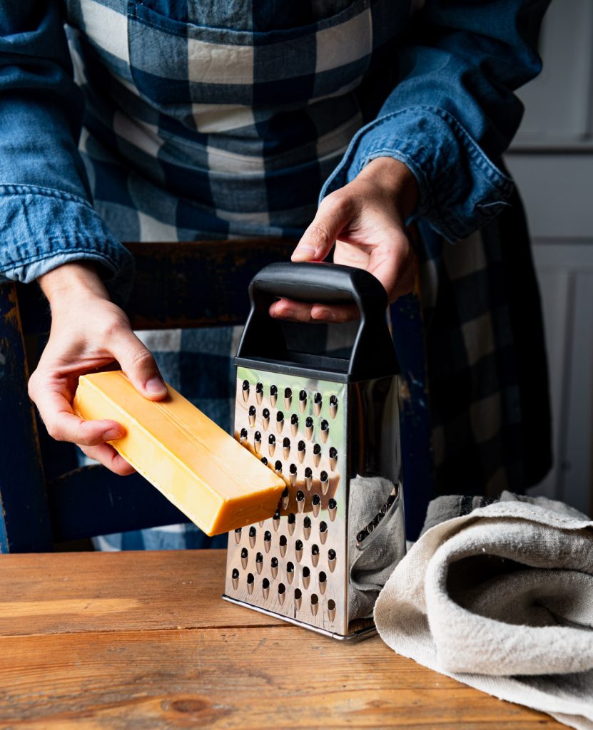 Grating a block of cheddar cheese
