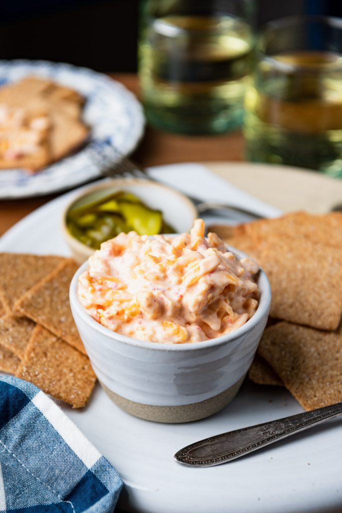 Side shot of southern pimento cheese served on a white tray with crackers