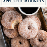 Overhead image of a tray of baked apple cider donuts with text title box at top