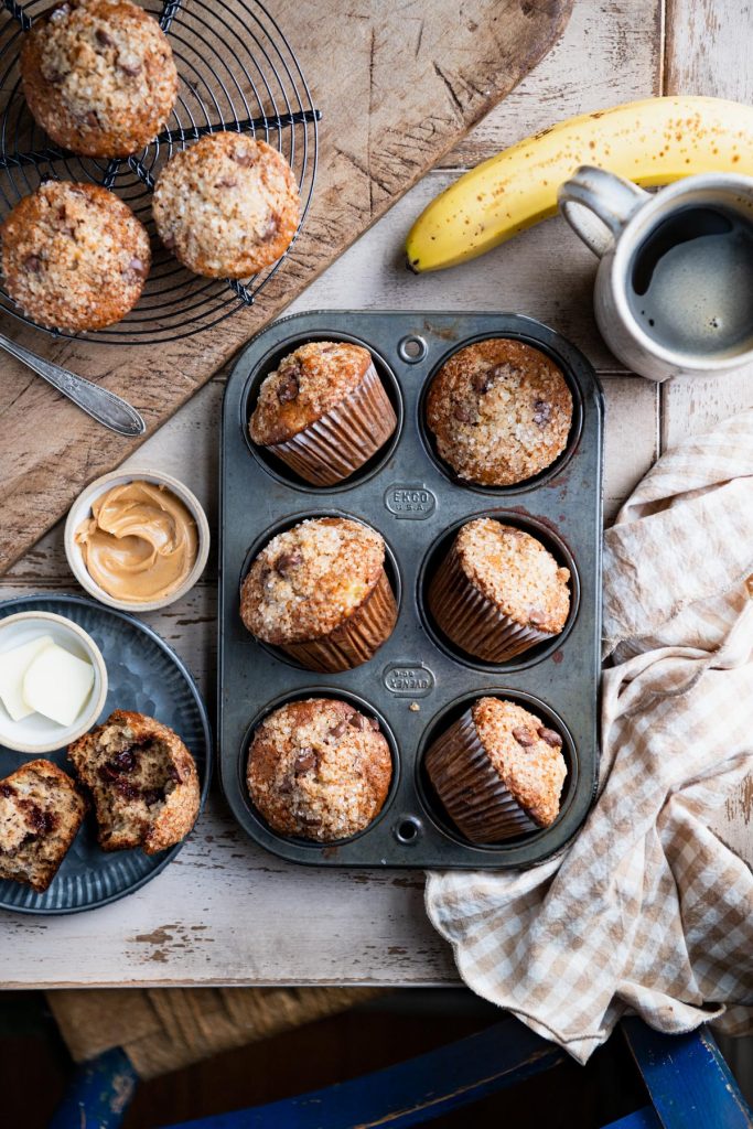 Overhead shot of banana chocolate chip muffins on a breakfast table
