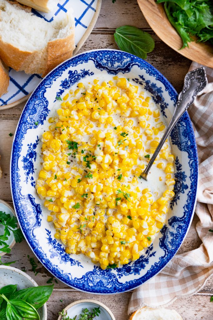 Overhead shot of crock pot creamed corn in a blue and white bowl