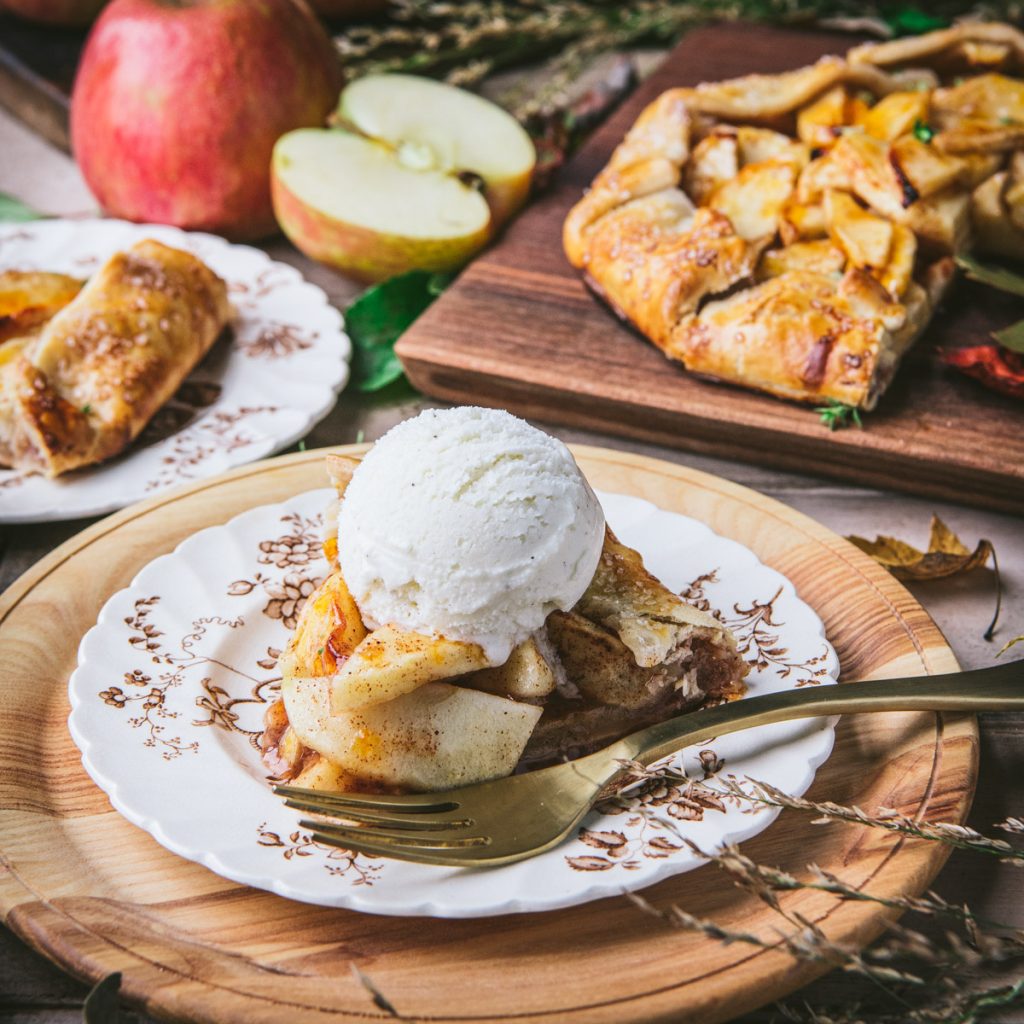 Square side shot of a slice of apple galette with ice cream on top