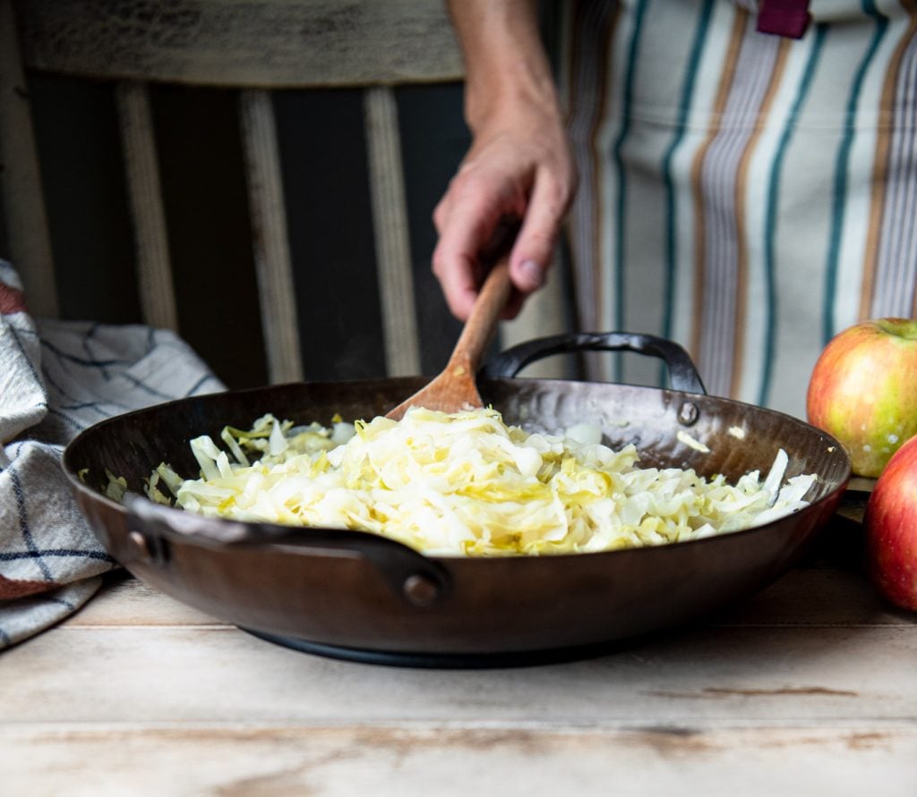 Stir frying cabbage in a cast iron skillet