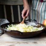 Stir frying cabbage in a cast iron skillet