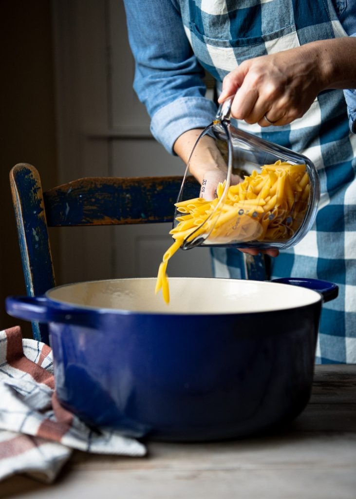 Pouring penne into a pot