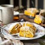 Square side shot of a plate of pumpkin scones on a breakfast table