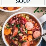 Bowl of sausage and bean soup with text title box at top