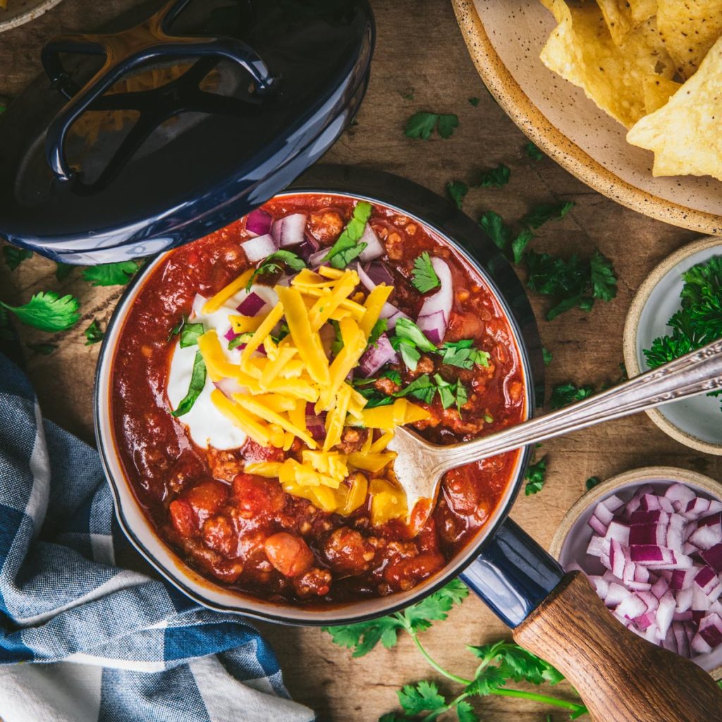 Square image of a spoon in a bowl of easy taco chili