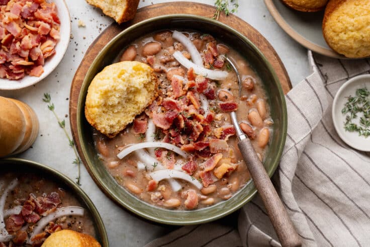 Horizontal overhead shot of a bowl of old fashioned pinto bean soup with a side of cornbread.