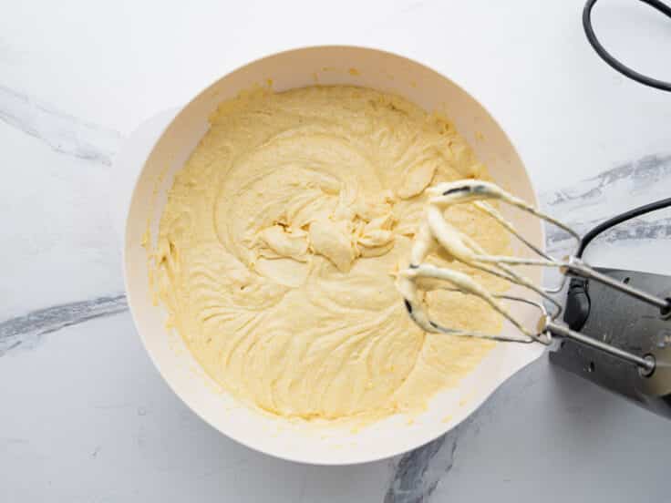 Process shot showing how to mix the batter for a Jiffy cornbread with cake mix recipe.