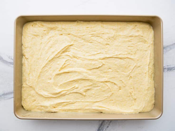 Cornbread with cake mix batter in a baking pan before it goes in the oven.