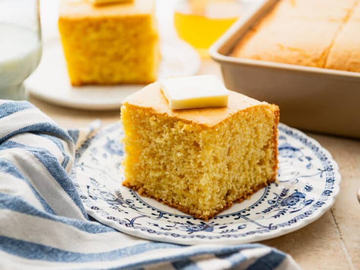 Horizontal side shot of cornbread cake on a plate.