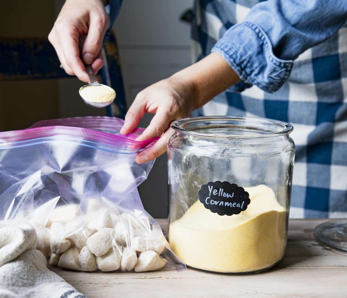Tossing chopped canned biscuit dough with cornmeal.