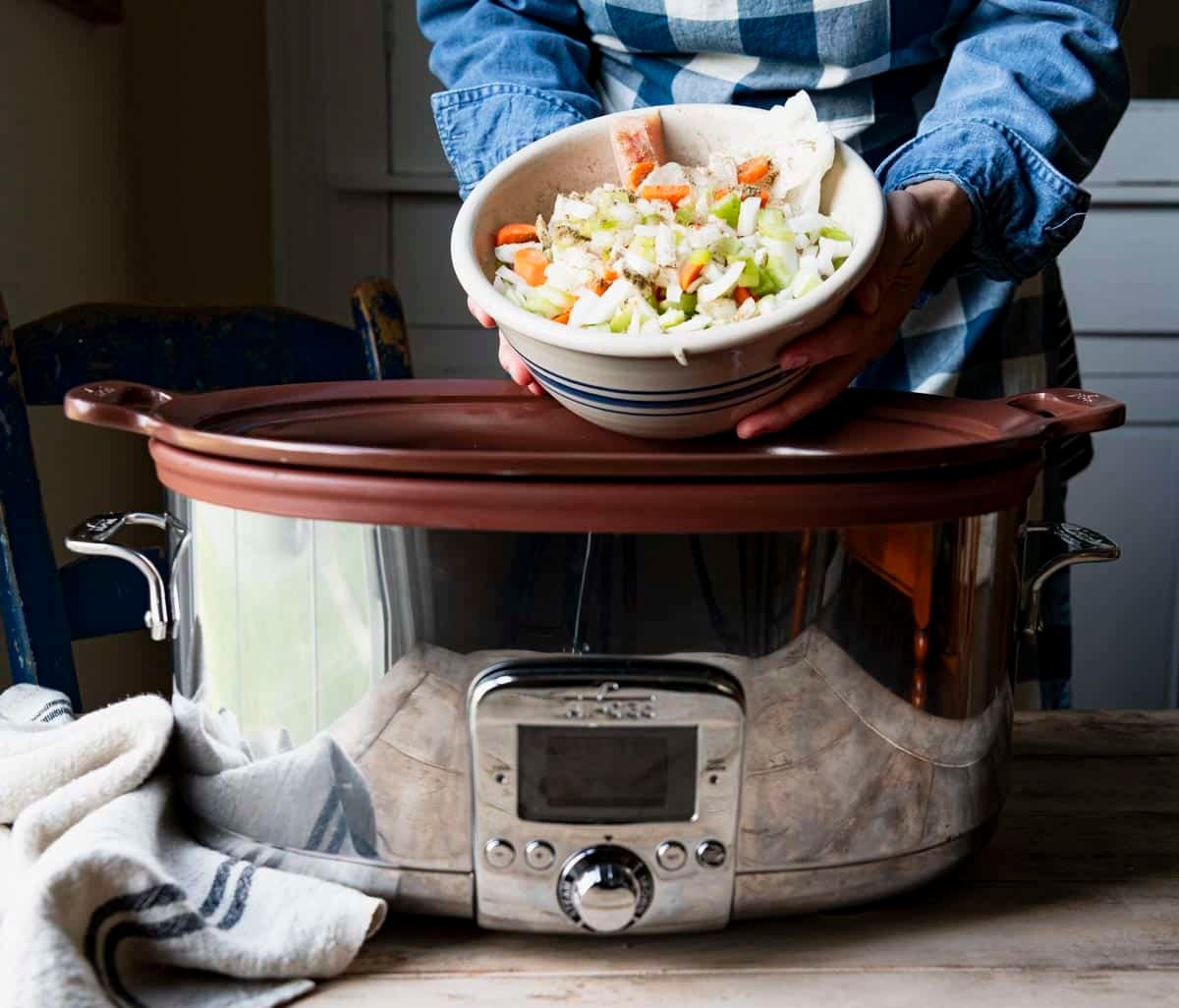 Adding vegetables to a slow cooker.