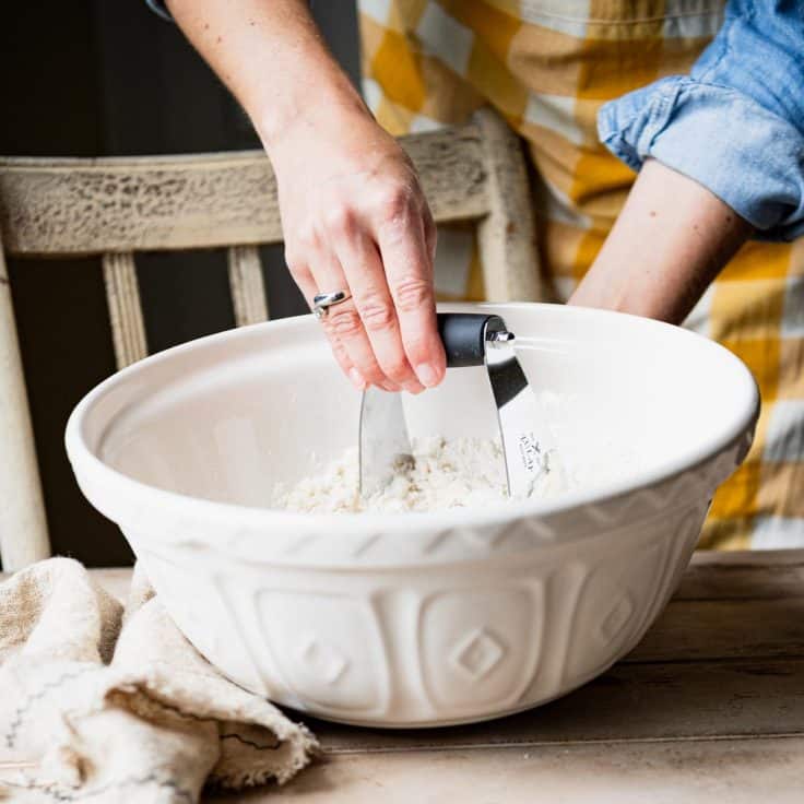 Cutting butter into a batch of 7up biscuit dough.