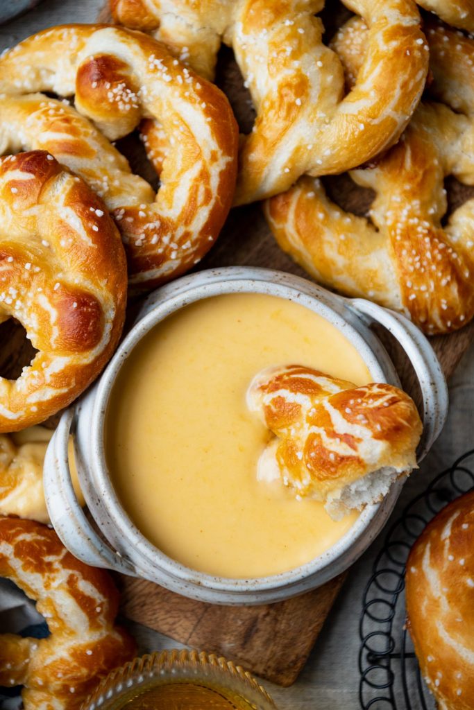 Overhead shot of a bowl of beer cheese dip with pretzels
