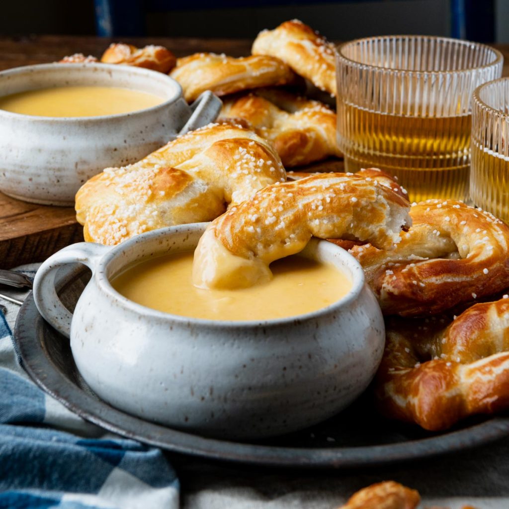 Square side shot of beer cheese pretzel dip on a table