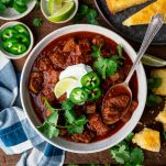 Square overhead image of texas chili on a wooden table