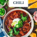 Hands eating a bowl of texas chili with text title overlay
