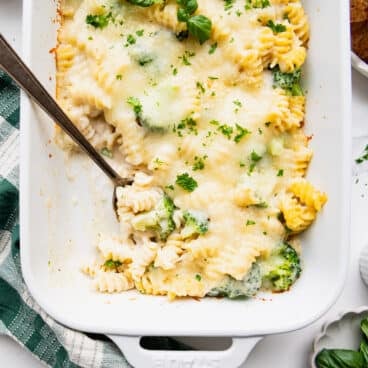 Square overhead shot of broccoli Alfredo pasta bake in a white casserole dish.
