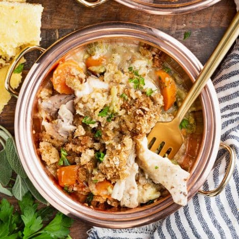 Square overhead image of crockpot chicken and stuffing in a copper bowl.