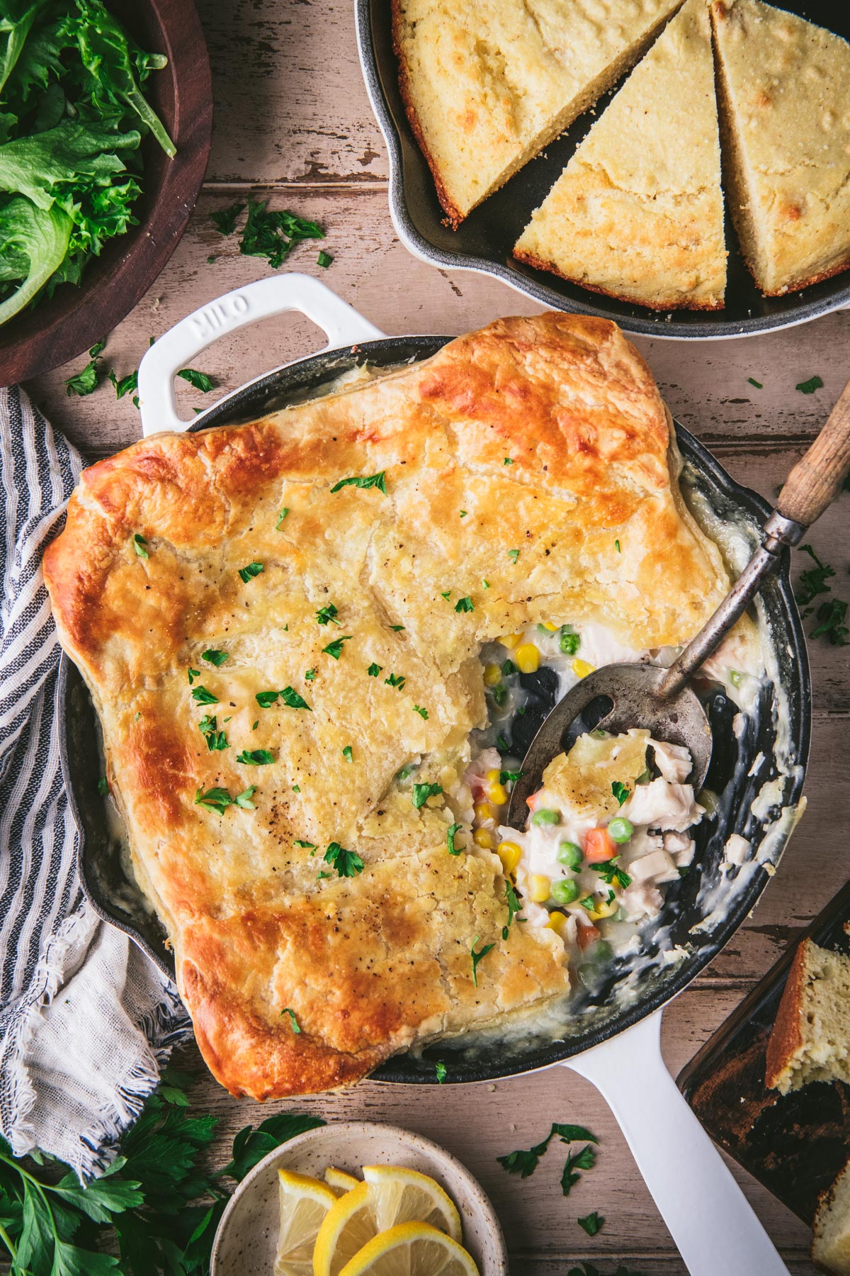 Overhead shot of chicken pot pie with puff pastry crust on a dinner table