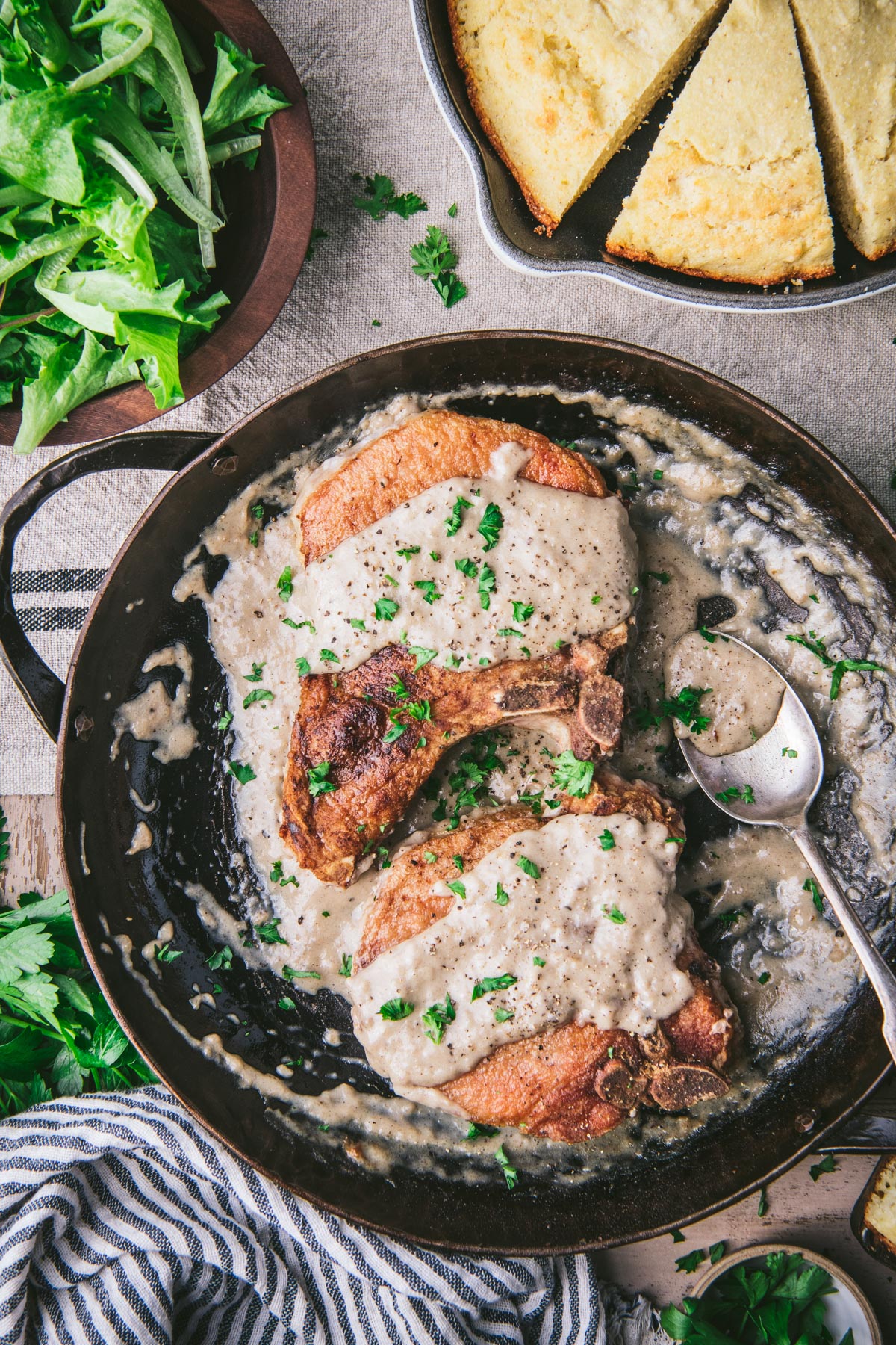 Skillet of pork chops and gravy on a dinner table
