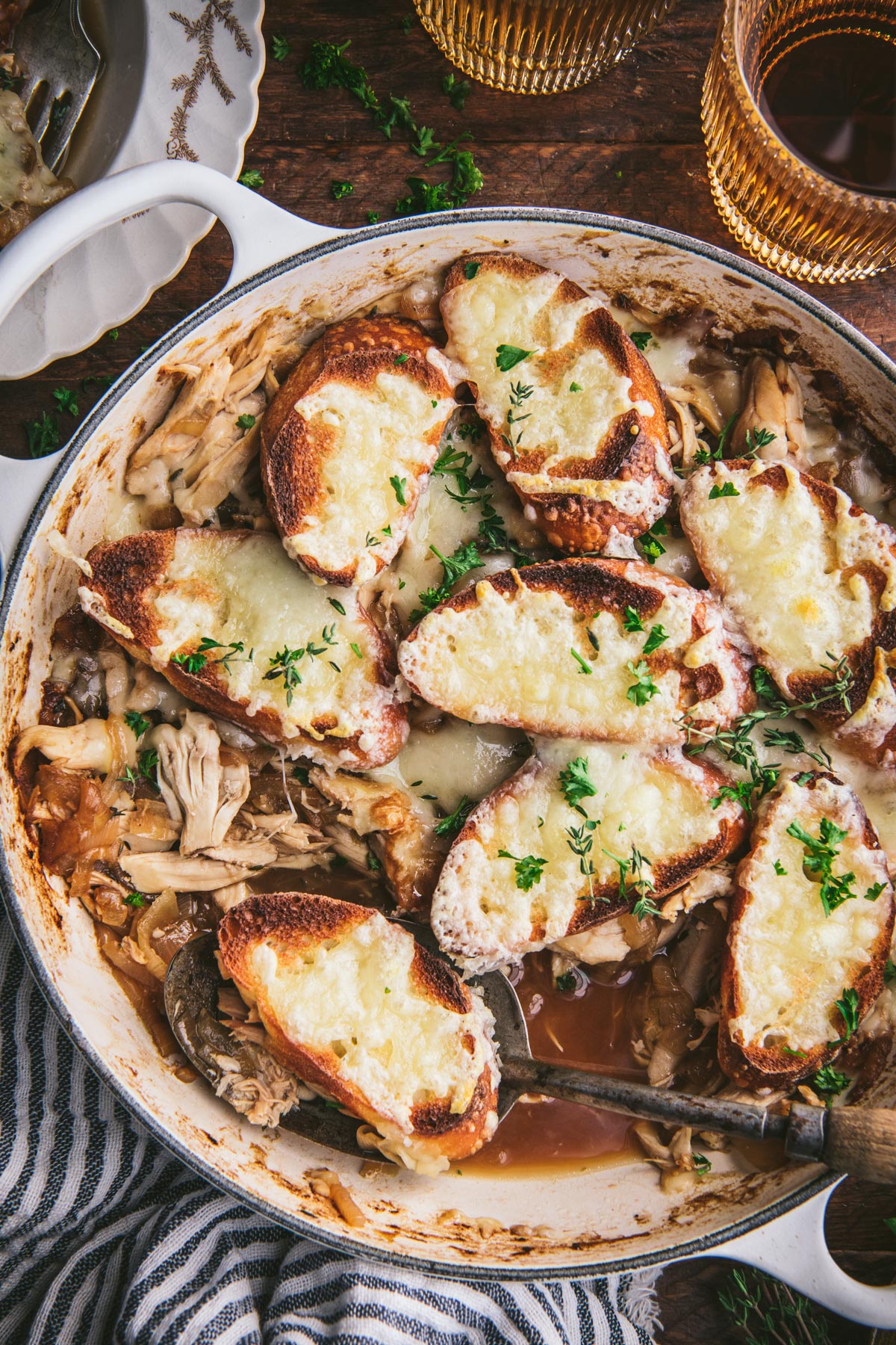 Close overhead image of french onion chicken bake in a skillet on a wooden table
