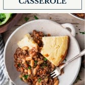 Overhead shot of a dish of ground beef and baked bean casserole with cornbread and text title box at top