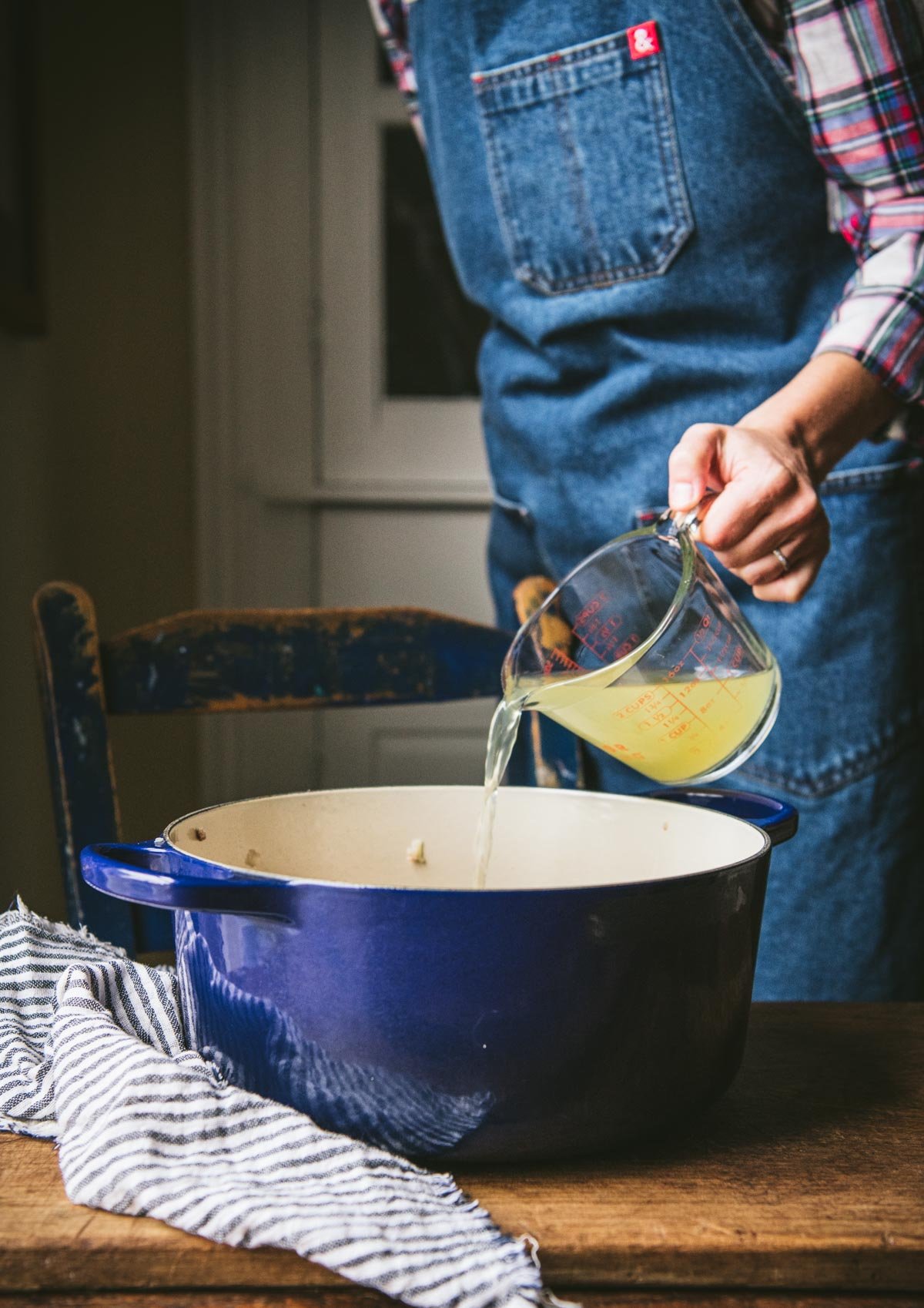 Pouring broth into a dutch oven