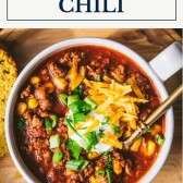 Overhead image of a bowl of ground turkey chili with a text title box at the top