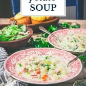 Side shot of ham and potato soup on a dinner table with text title overlay