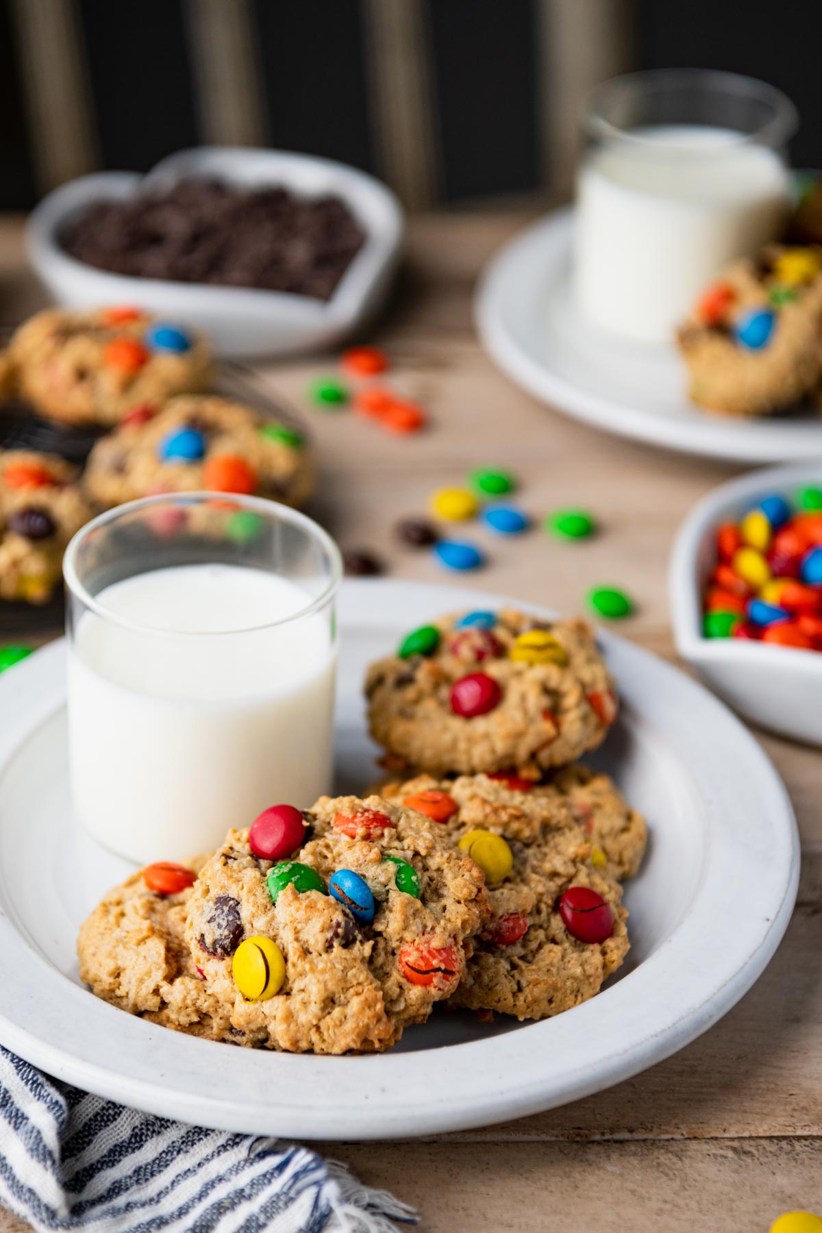 Close up shot of a white plate of monster cookies on a table