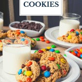 White plate full of monster cookies and glasses of milk with text title overlay