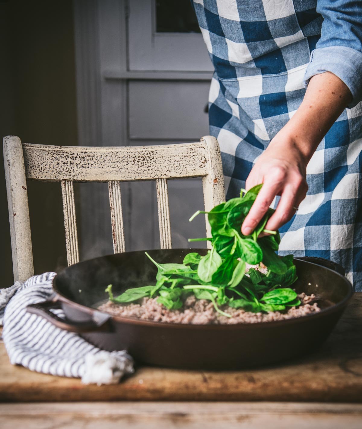 Adding spinach to skillet with Italian sausage