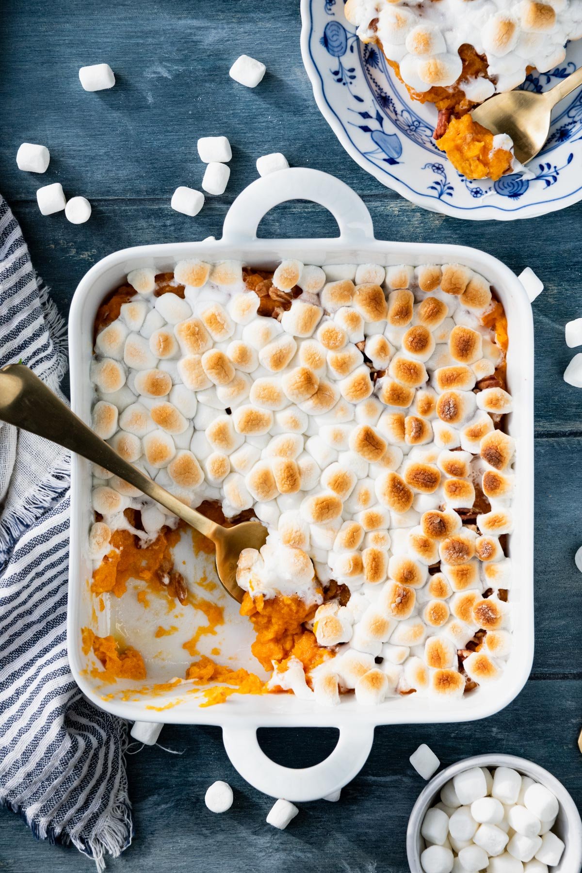 White dish of sweet potato casserole on a blue table