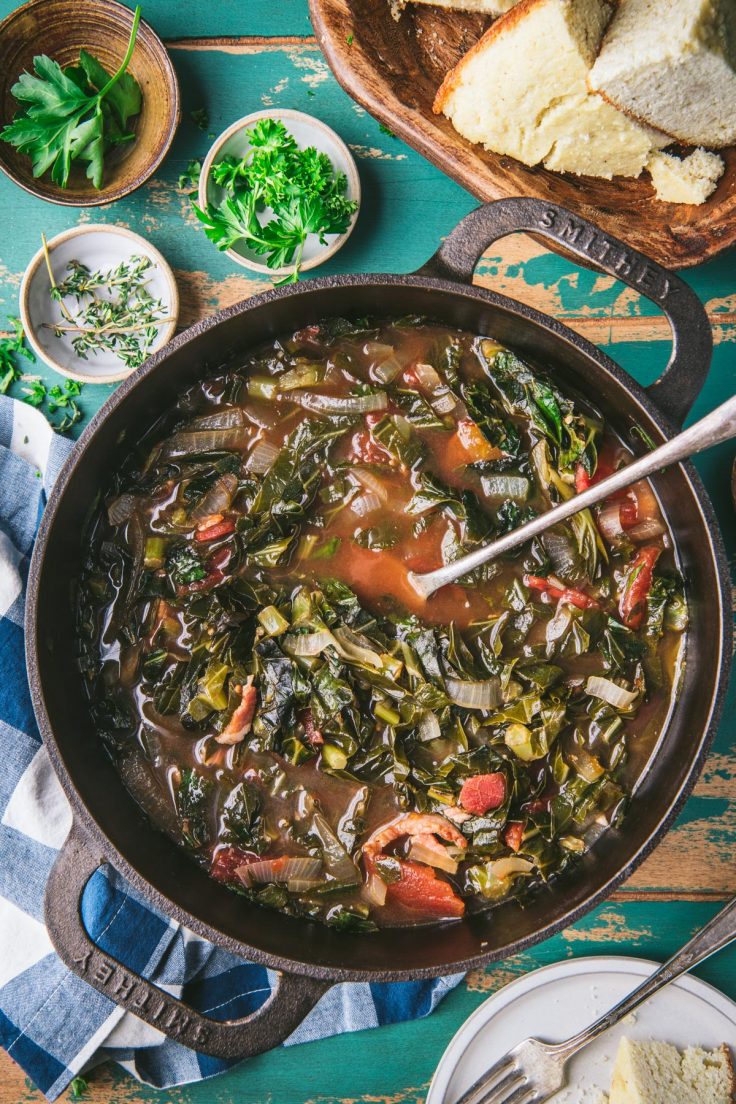 Long overhead shot of collard greens with bacon in a Dutch oven