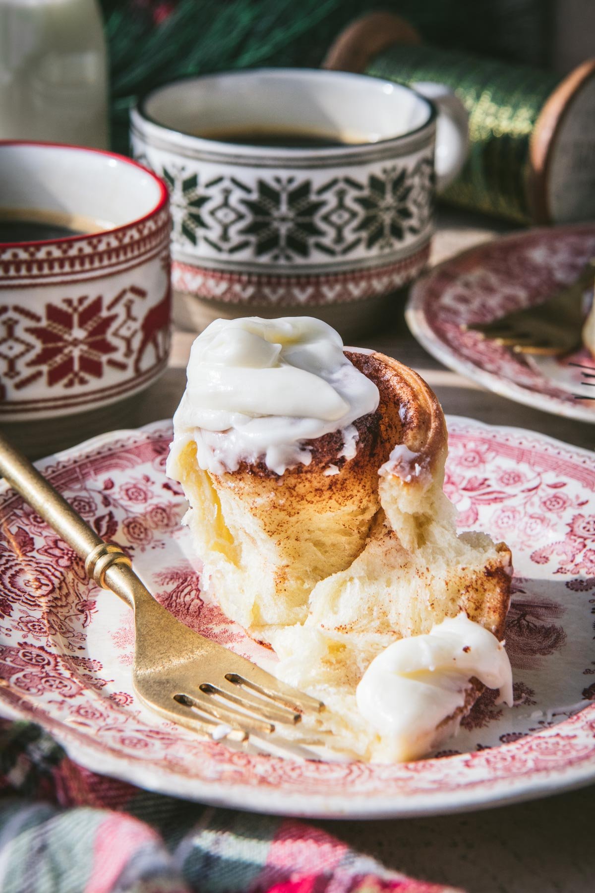 Fluffy cinnamon roll on a plate with cream cheese frosting