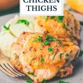 Close up shot of roasted chicken thighs with text title overlay.