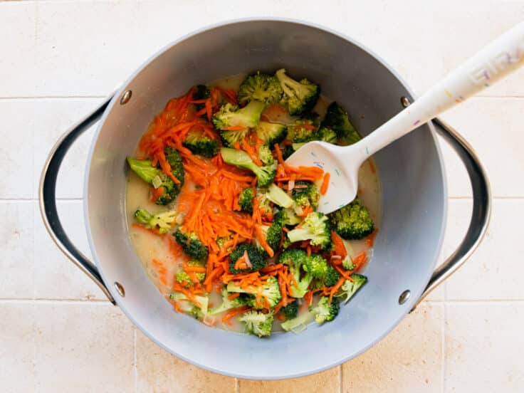 Adding the vegetables to a pot of soup.