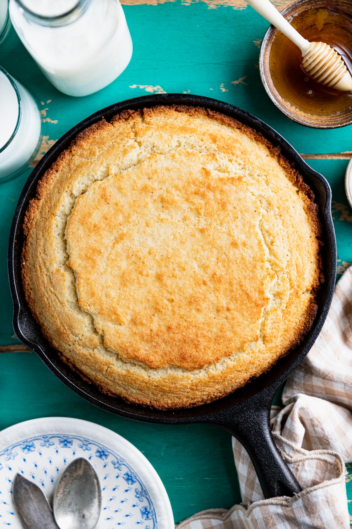 Overhead shot of cast iron cornbread on a rustic wooden table