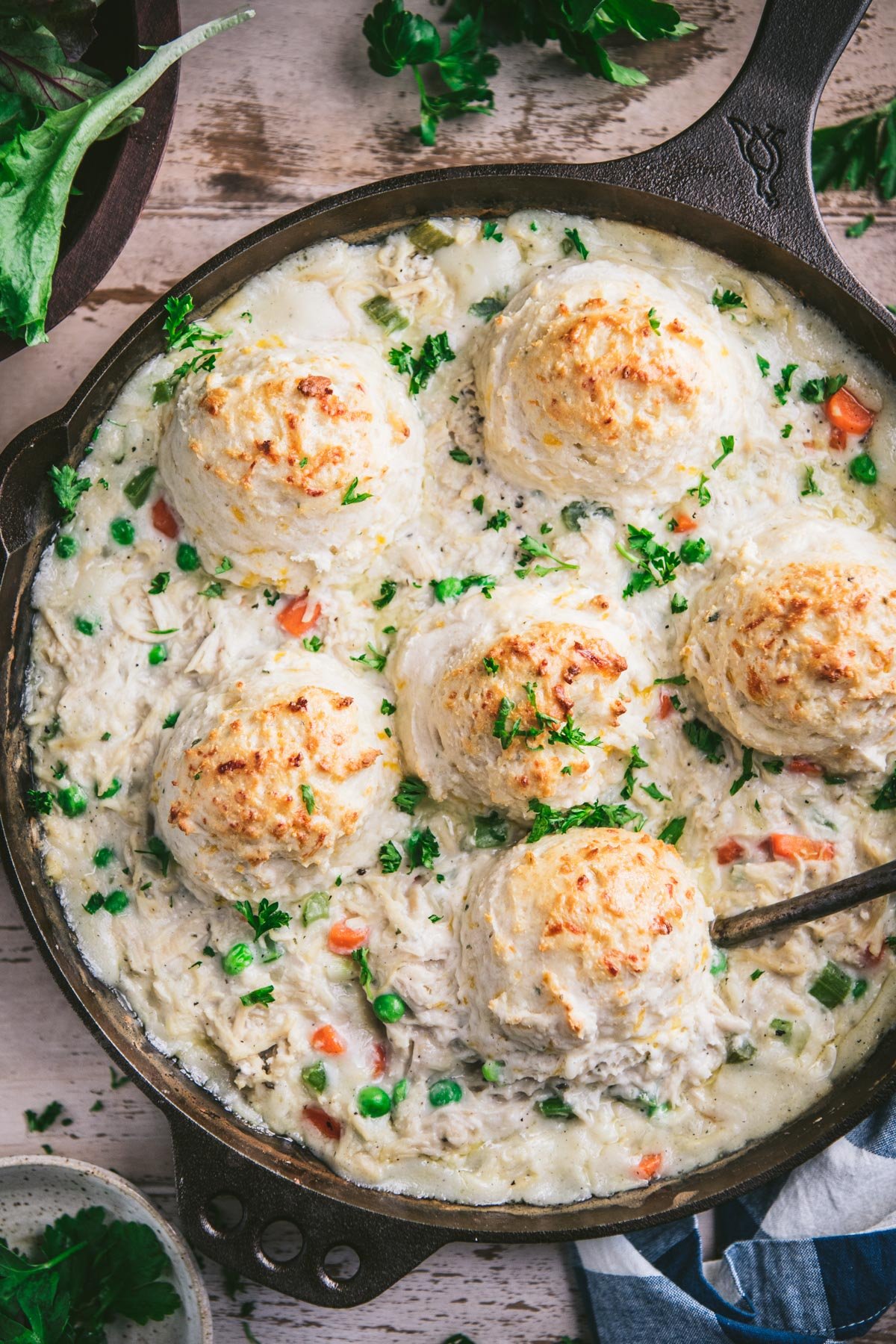 Close overhead image of creamed chicken and biscuits casserole on a wooden table