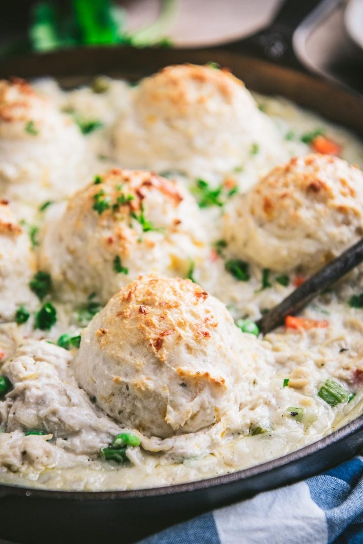 Close up front shot of creamy chicken and biscuits in a cast iron pan