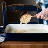 Pouring rice into a baking dish.