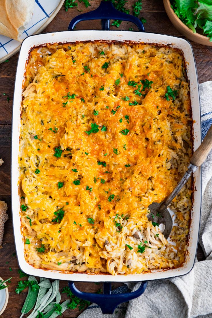 Serving spoon in a blue pan of dump and bake cheesy chicken and rice casserole