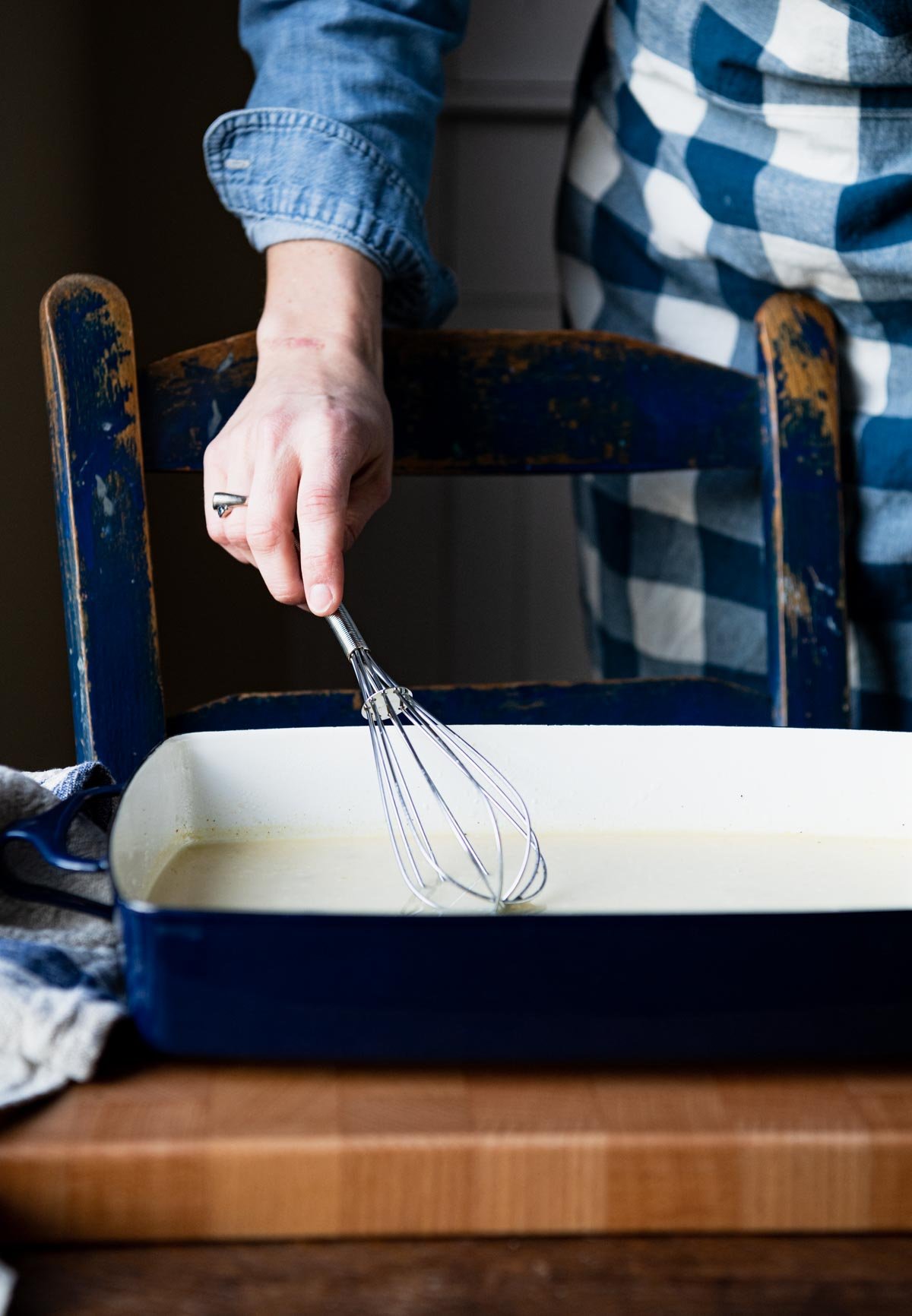 Whisking together sauce in a baking dish.