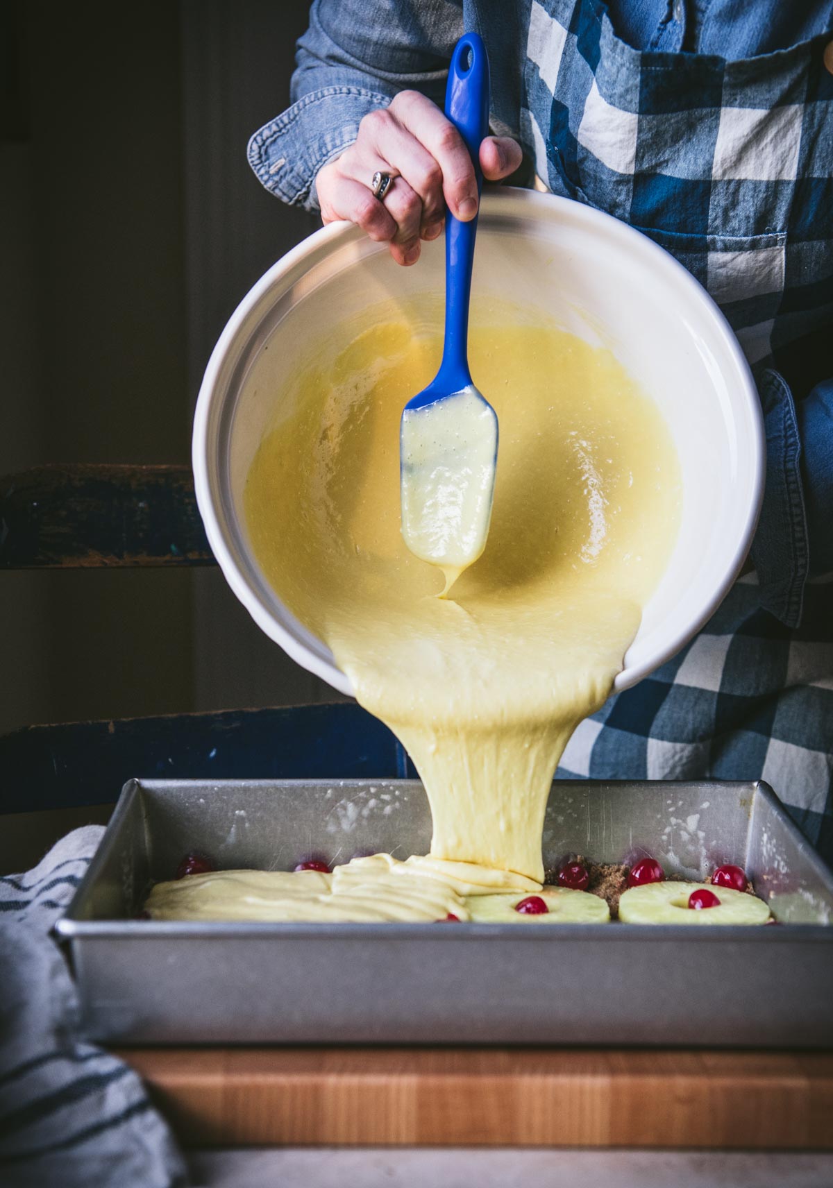 Pouring cake mix batter into a pan.